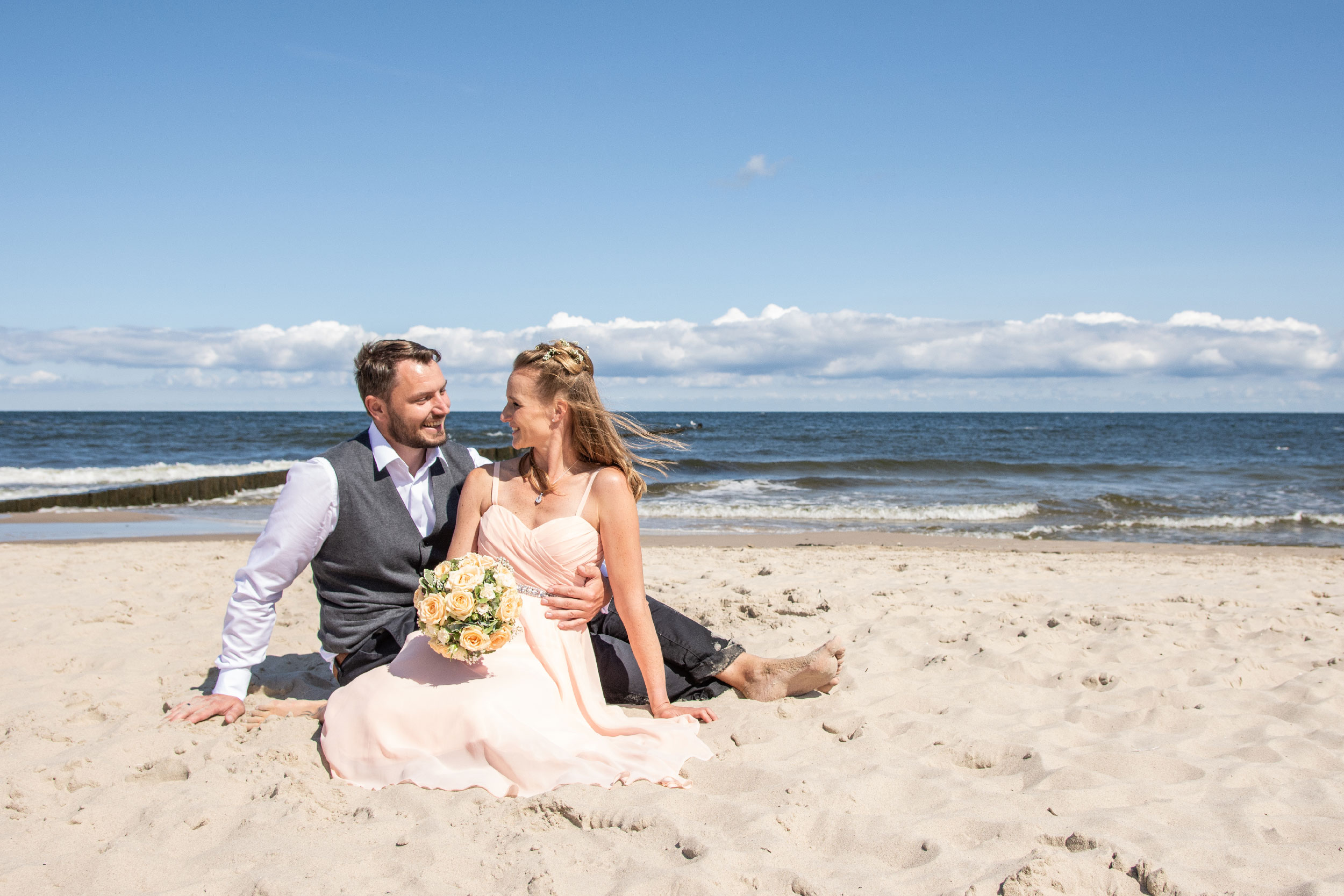 Hochzeitsfoto Brautpaar lacht am Strand lustig