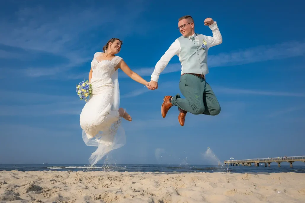 Brautpaar springt am Strand